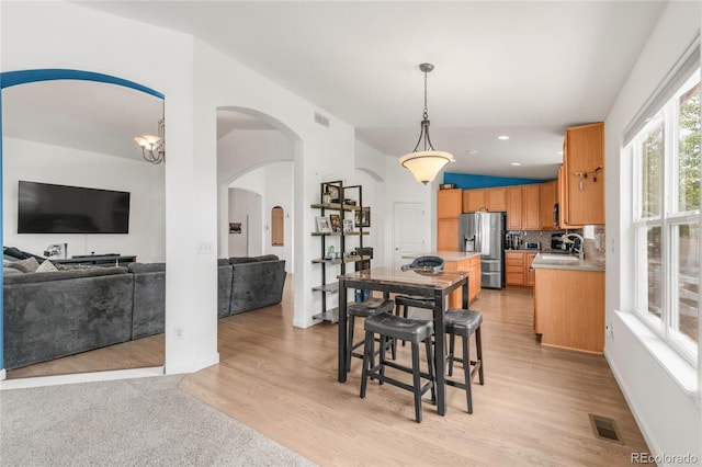 1510 S De Gaulle Cir, Aurora, CO 80018 - dining area with light wood-style flooring, arched walkways, and recessed lighting