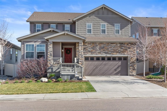 craftsman-style home featuring a garage, driveway, stone siding, and a front yard