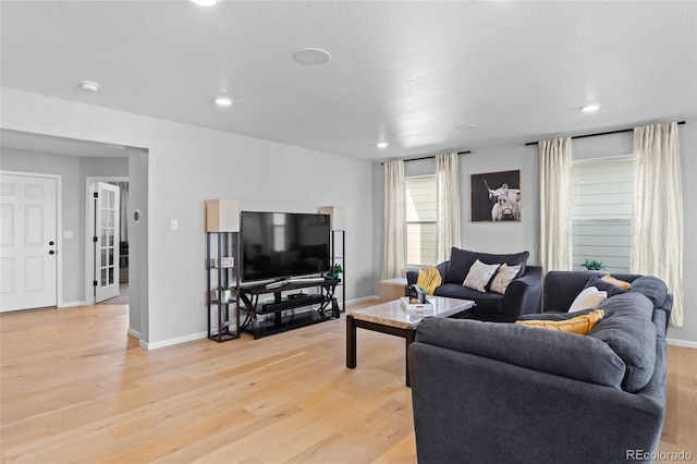 living room with light wood-type flooring, baseboards, and recessed lighting