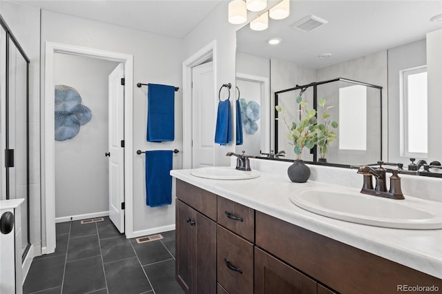 full bath with a shower stall, tile patterned floors, double vanity, and baseboards
