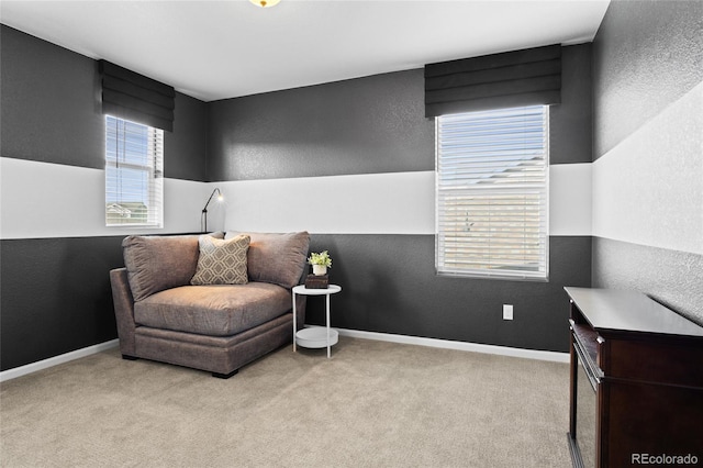sitting room with a textured wall, carpet flooring, and baseboards