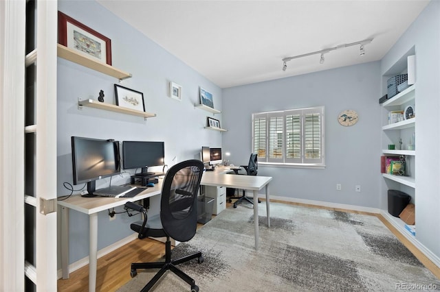 office area with track lighting, baseboards, and wood finished floors