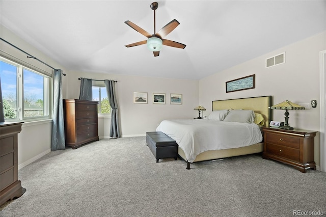 bedroom with ceiling fan, visible vents, vaulted ceiling, carpet floors, and baseboards