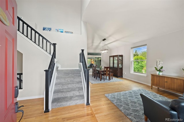 entryway featuring baseboards, stairs, wood finished floors, and a healthy amount of sunlight