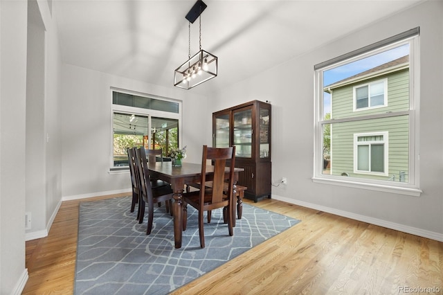 dining area featuring baseboards, wood finished floors, and a chandelier
