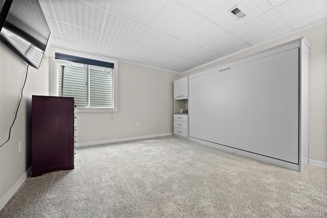 empty room featuring baseboards, light carpet, and visible vents
