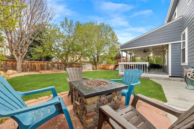 view of patio featuring a fenced backyard, a ceiling fan, and a fire pit