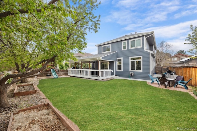 back of property featuring a fenced backyard, a garden, a playground, a patio, and a lawn