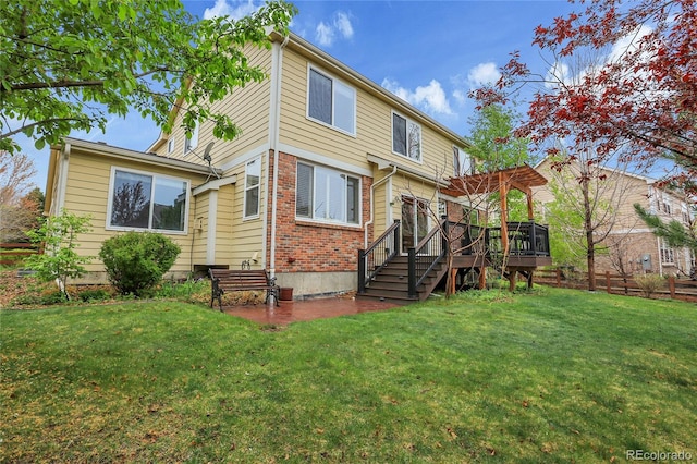 back of property with a lawn, brick siding, a pergola, and a deck