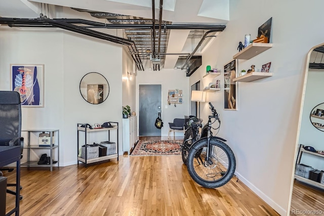 interior space featuring a towering ceiling and hardwood / wood-style flooring