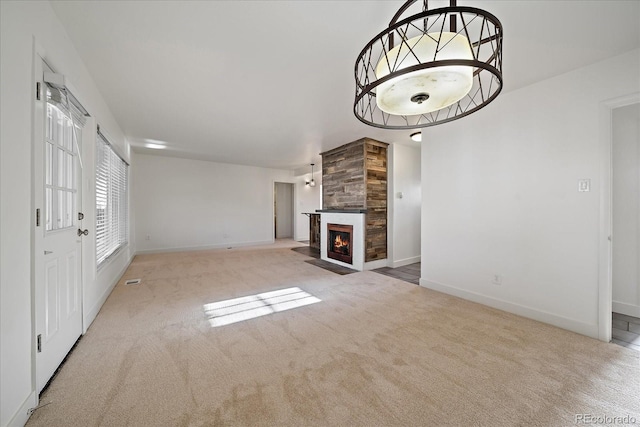 unfurnished living room with a tiled fireplace and light colored carpet