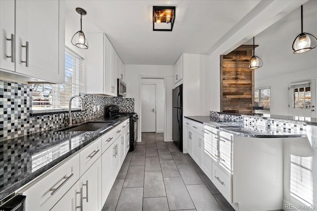 kitchen with black appliances, decorative backsplash, white cabinets, and hanging light fixtures