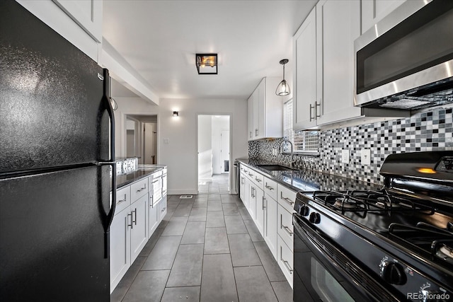 kitchen featuring pendant lighting, black appliances, sink, decorative backsplash, and white cabinetry