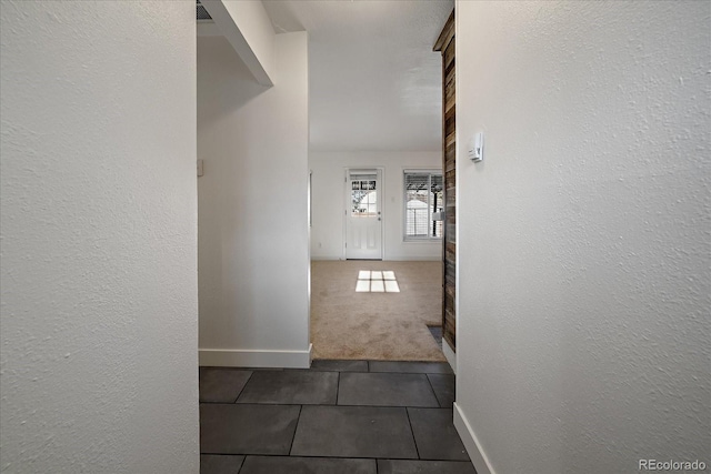 hall with dark colored carpet