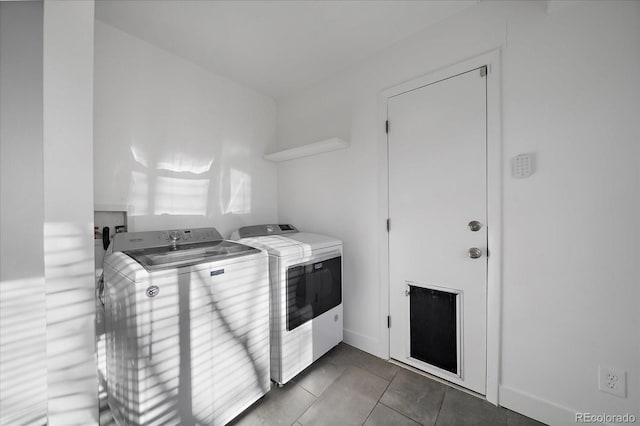 laundry area with dark tile patterned flooring and washing machine and clothes dryer