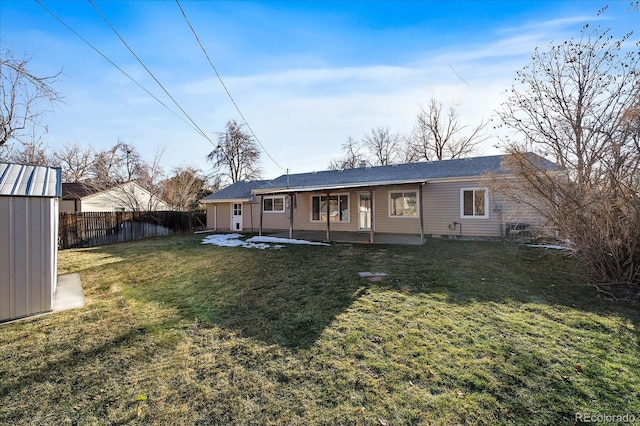 rear view of house with a lawn, a patio area, and a storage shed