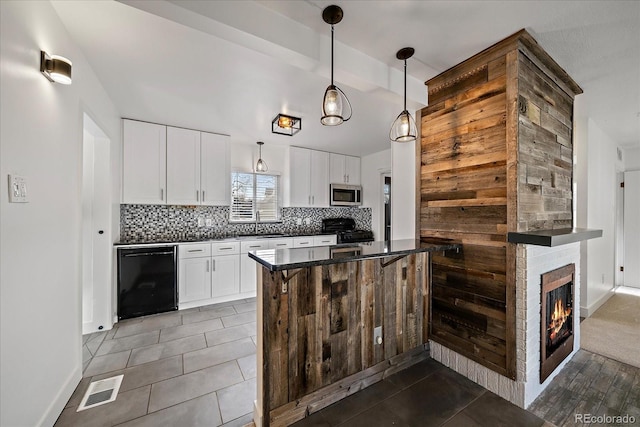 kitchen featuring dark countertops, tile patterned floors, decorative backsplash, and black appliances