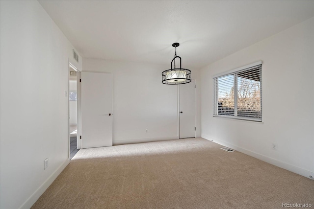 unfurnished room featuring visible vents, baseboards, and light carpet