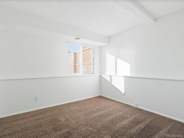 empty room featuring carpet floors, plenty of natural light, beamed ceiling, and a textured ceiling