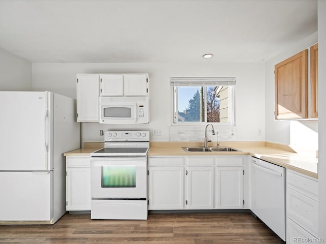 kitchen with white cabinetry, white appliances, dark hardwood / wood-style floors, and sink