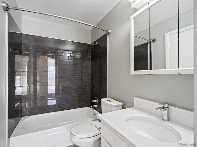 full bathroom featuring tiled shower / bath, vanity, and toilet