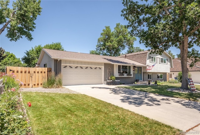 5983 W Indore Pl, Littleton, CO 80128 - split level home featuring an attached garage, driveway, brick siding, roof with shingles, and board and batten siding
