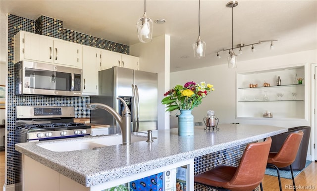 5983 W Indore Pl, Littleton, CO 80128 - kitchen featuring stainless steel appliances, pendant lighting, light stone counters, and white cabinetry
