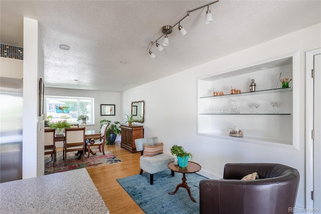 5983 W Indore Pl, Littleton, CO 80128 - living room featuring a textured ceiling, wood finished floors, and rail lighting