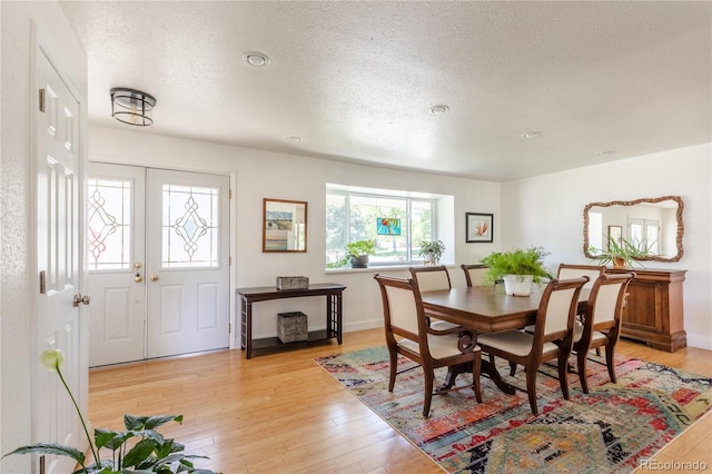 5983 W Indore Pl, Littleton, CO 80128 - dining space with a textured ceiling, light wood-style floors, and french doors