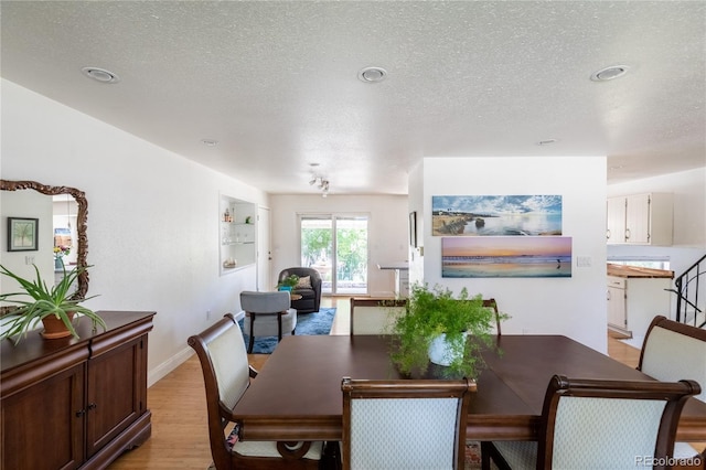 5983 W Indore Pl, Littleton, CO 80128 - dining area featuring light wood-type flooring, a textured ceiling, and recessed lighting