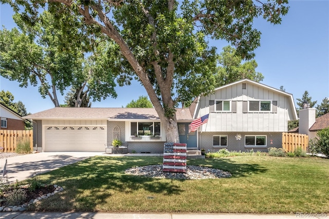 5983 W Indore Pl, Littleton, CO 80128 - split level home with board and batten siding, brick siding, concrete driveway, and an attached garage