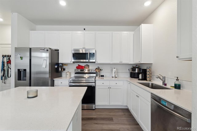 kitchen featuring sink, dark wood-type flooring, appliances with stainless steel finishes, light stone counters, and white cabinets