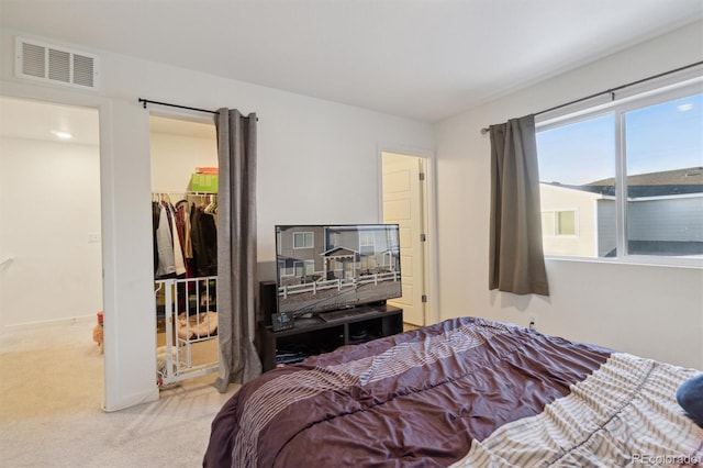 bedroom with a closet, carpet, and a walk in closet