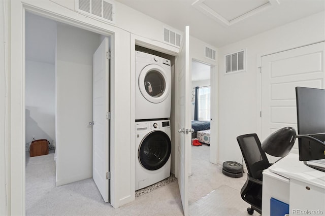 washroom with stacked washer / drying machine and light carpet