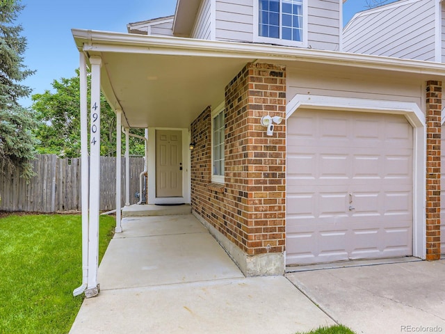 4904 E 125th Ave, Thornton, CO 80241 - view of exterior entry featuring a garage and brick siding