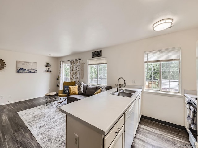 4904 E 125th Ave, Thornton, CO 80241 - kitchen featuring dishwasher, dark wood-style flooring, a peninsula, open floor plan, and light countertops