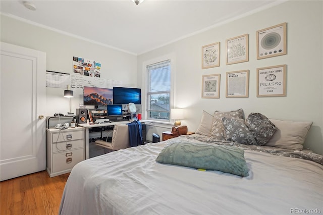 bedroom featuring ornamental molding, wood finished floors, and an office area