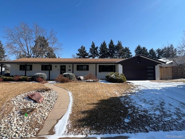 single story home featuring driveway, an attached garage, and stucco siding