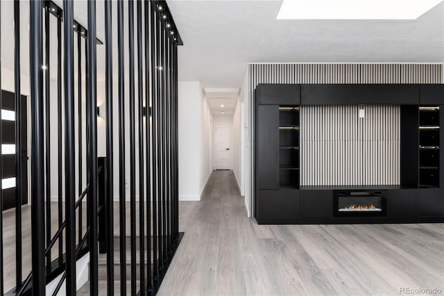 hall featuring light wood finished floors and baseboards