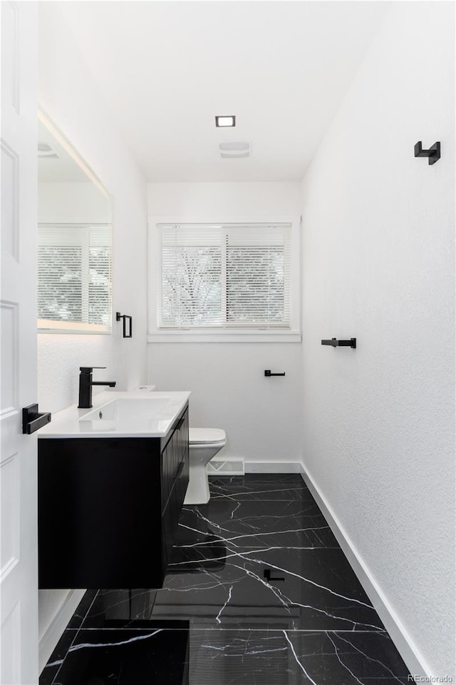 bathroom with marble finish floor, visible vents, toilet, vanity, and baseboards