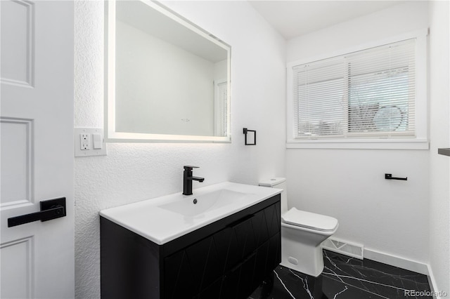 bathroom with marble finish floor, visible vents, toilet, vanity, and baseboards