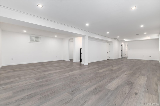 finished below grade area with light wood-style flooring, baseboards, and recessed lighting