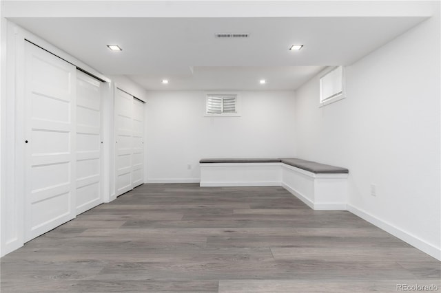 finished below grade area with visible vents, baseboards, wood finished floors, and recessed lighting