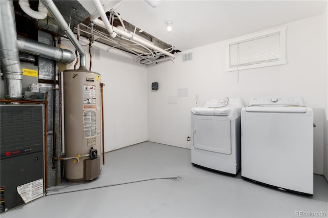 clothes washing area with laundry area, visible vents, gas water heater, and independent washer and dryer