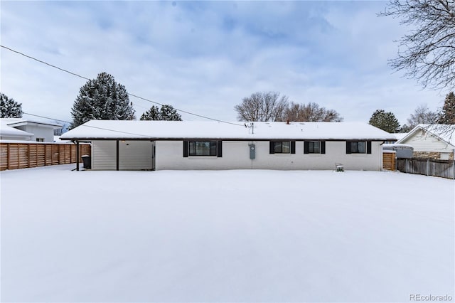 snow covered house featuring fence