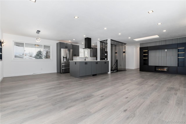 5886 S Logan St, Centennial, CO 80121 - unfurnished living room featuring light wood finished floors, recessed lighting, baseboards, and a sink