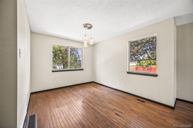 12099 Forest St, Thornton, CO 80241 - spare room featuring hardwood / wood-style floors and a textured ceiling
