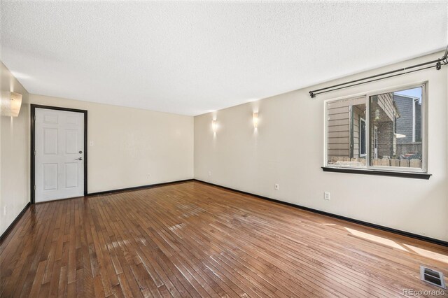 12099 Forest St, Thornton, CO 80241 - empty room featuring hardwood / wood-style flooring and a textured ceiling