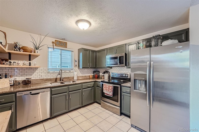 kitchen with stainless steel appliances, a textured ceiling, sink, light tile patterned flooring, and tasteful backsplash