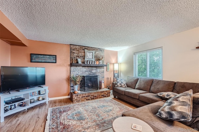 living room with a textured ceiling, a fireplace, and hardwood / wood-style flooring